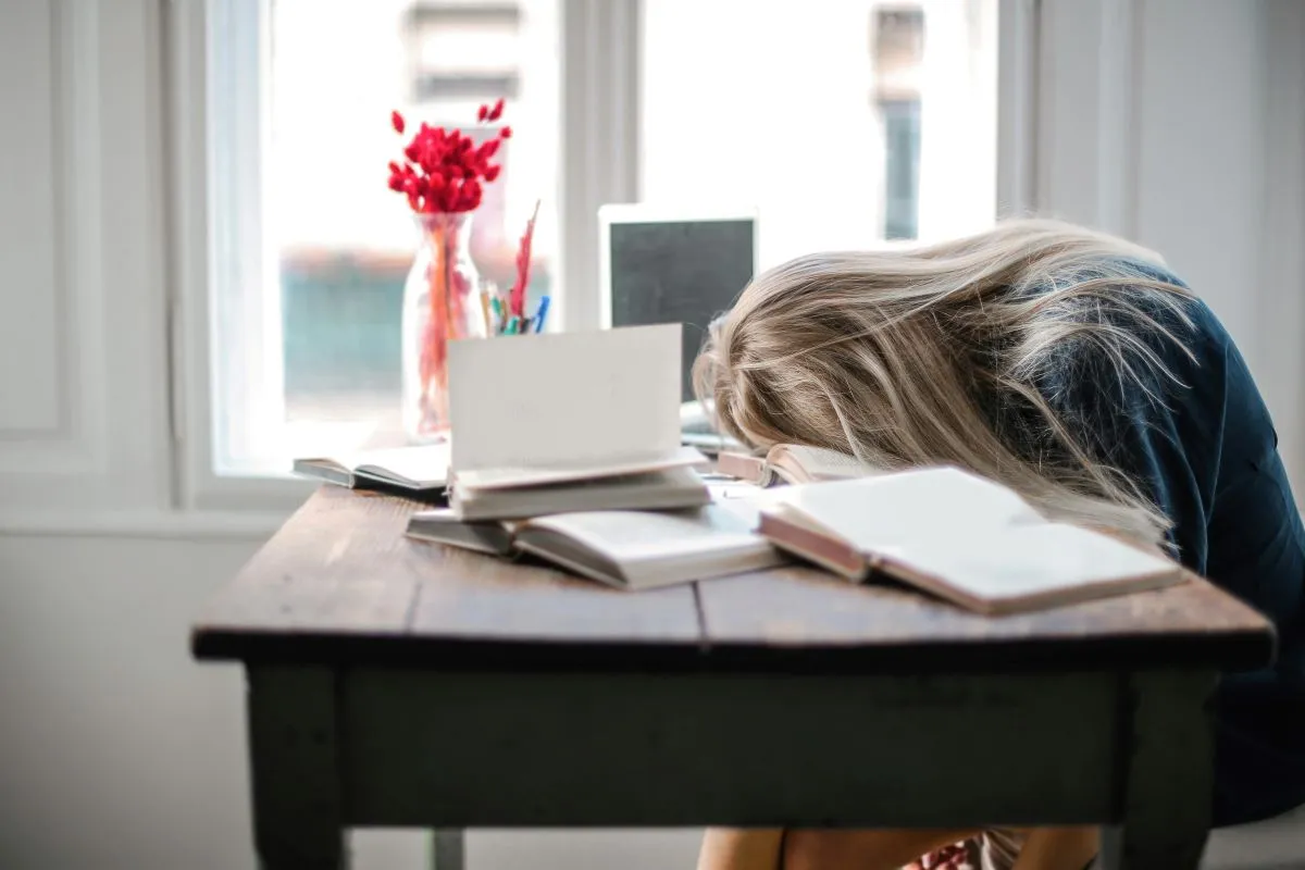 Joven dormida sobre la mesa para ilustrar el post sobre los síntomas de TDA en niños