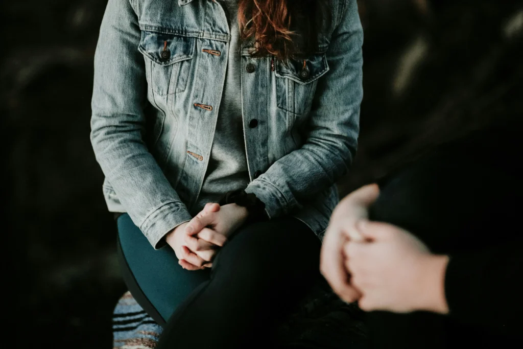 Una chica en la consulta de un psicólogo del que se desconoce el sexo