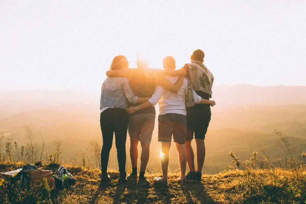 Foto de un grupo de amigos o familia en la montaña viendo el atardecer para ilustrar un post sobre terapia sistémica